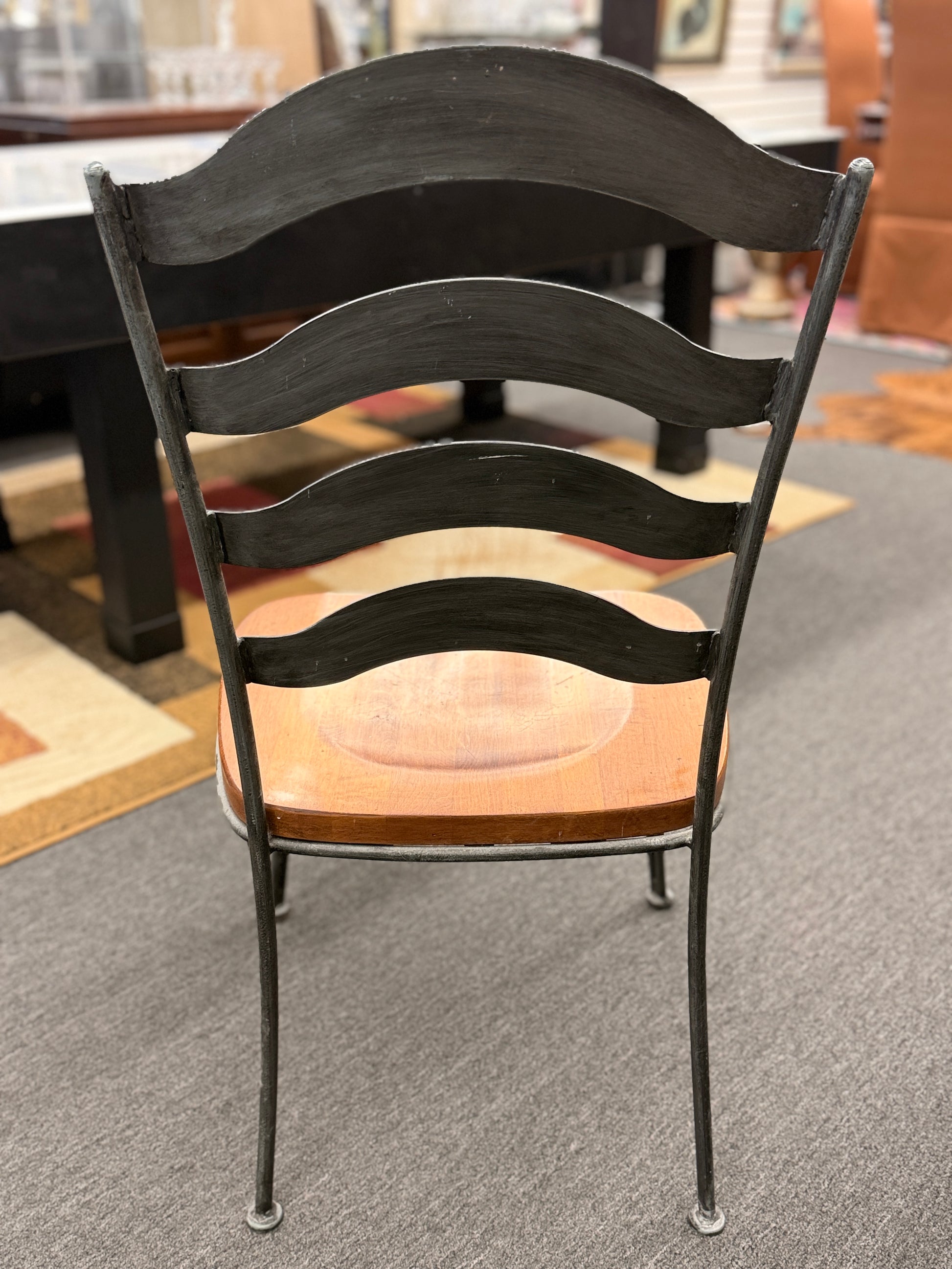 Five-piece round dining set featuring a natural wood tabletop, four matching chairs with wood seats, and decorative curved metal frames with scrollwork.