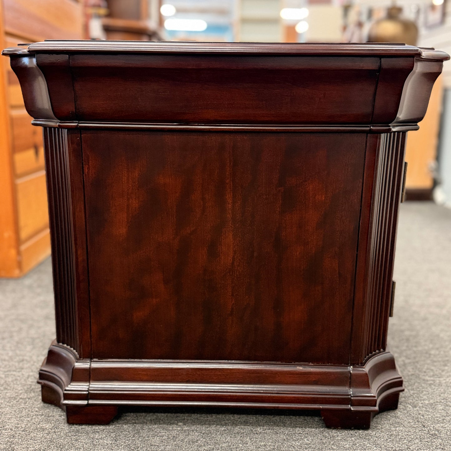Traditional dark wood nightstand featuring a top drawer, lower cabinet door, fluted corner details, and a classic timeless design.