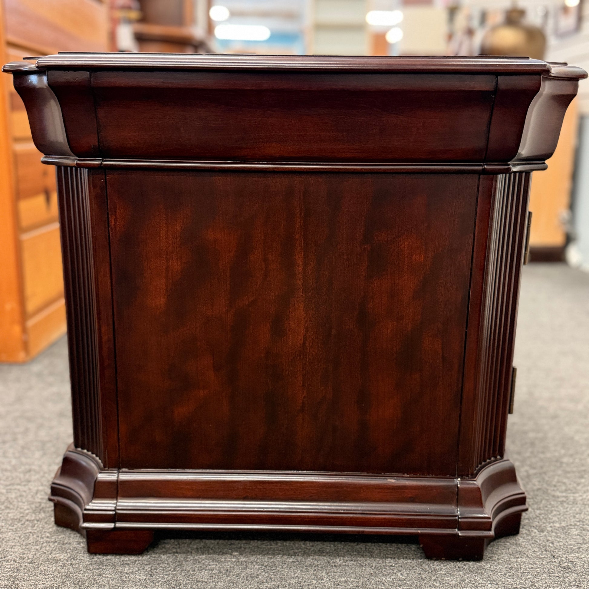 Traditional dark wood nightstand featuring a top drawer, lower cabinet door, fluted corner details, and a classic timeless design.
