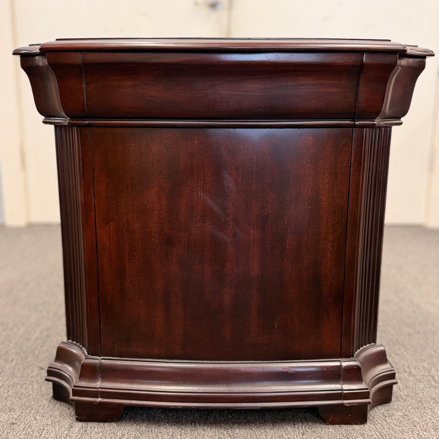 Traditional dark wood nightstand featuring a top drawer, lower cabinet door, fluted corner details, and a classic timeless design.