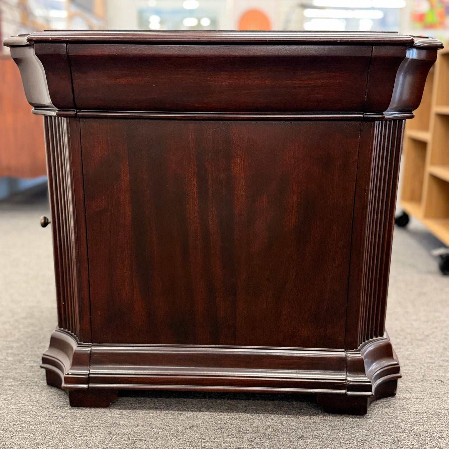 Traditional dark wood nightstand featuring a top drawer, lower cabinet door, fluted corner details, and a classic timeless design.