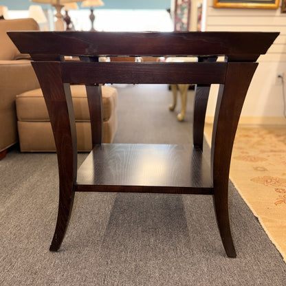 Square dark wood end table featuring a glass top with an intricate woven metal inlay and a lower display shelf.