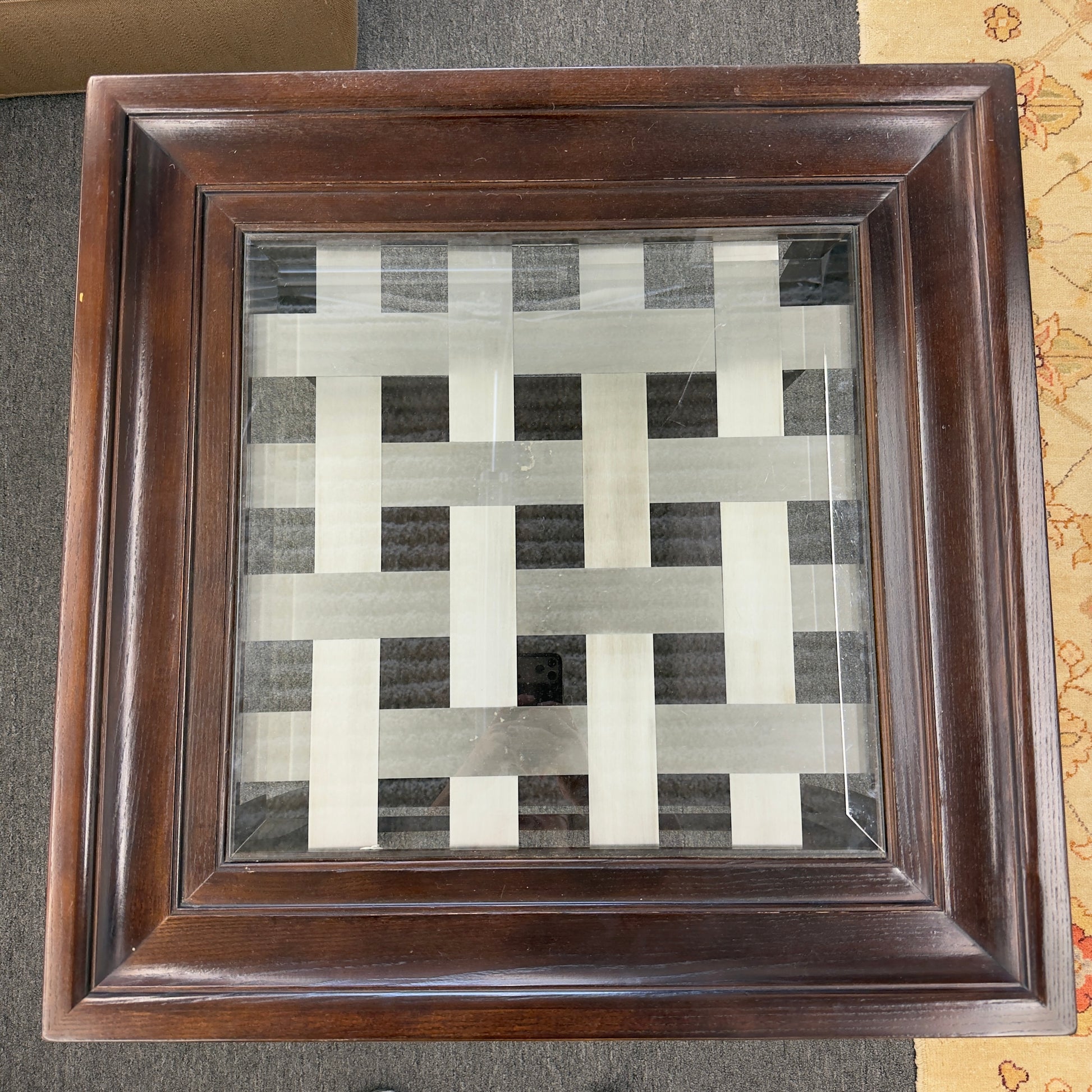 Square dark wood end table featuring a glass top with an intricate woven metal inlay and a lower display shelf.