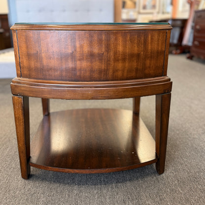 Dark wood nightstand featuring a glass insert top, a single drawer with a silver ring pull, and an open lower display shelf.