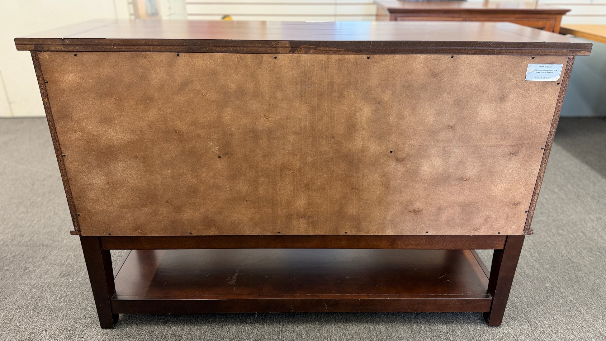 A medium-brown wooden console server featuring a central drawer, open center cubby, two louvered side doors, and a full-length lower display shelf.