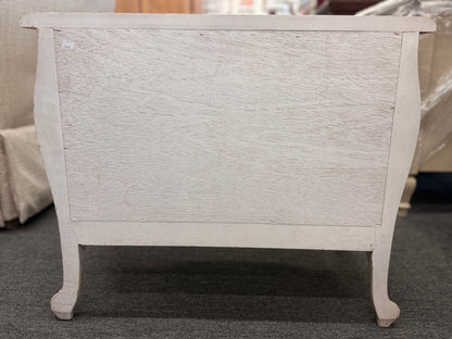 A French Provincial style two-drawer nightstand in a distressed antique-white finish featuring a serpentine front, cabriole legs, and ornate iron pulls.