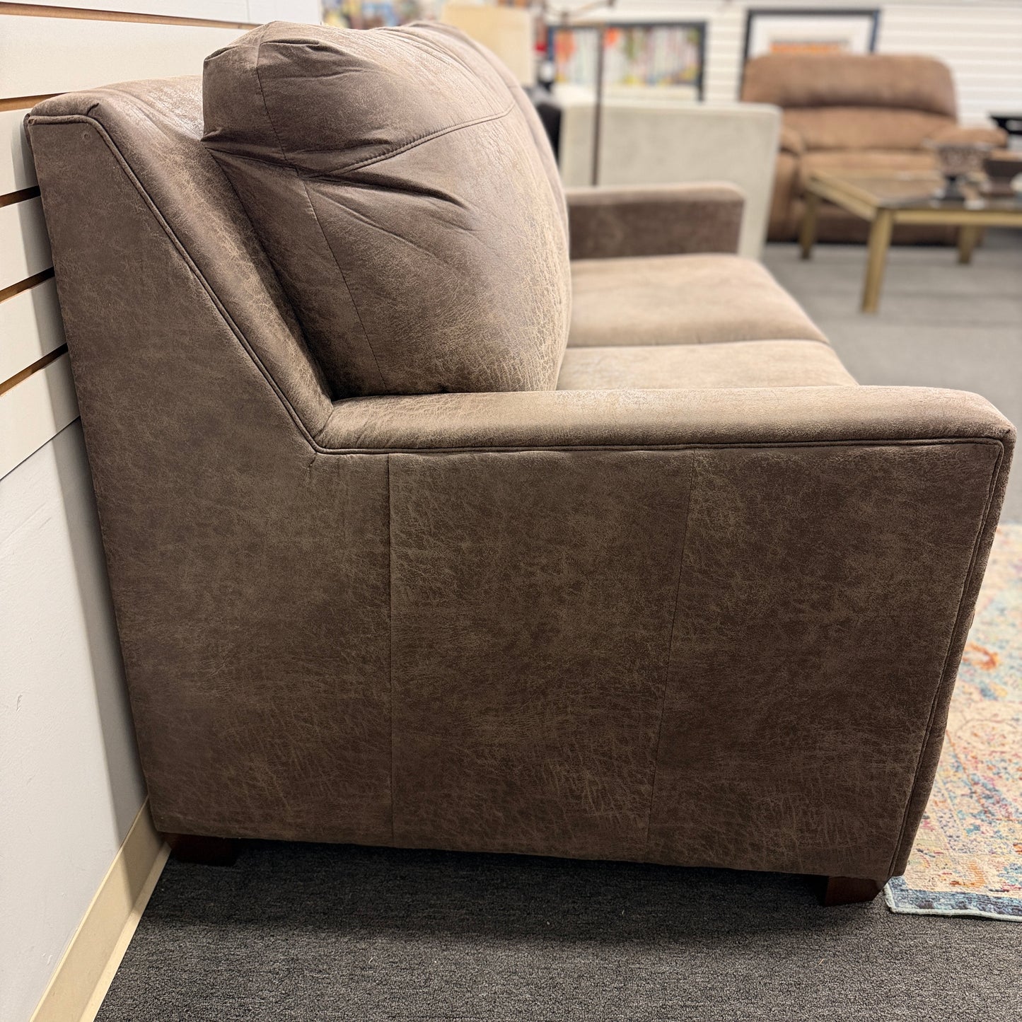 A plush two-seater sleeper sofa with pillow-top backrests and tapered track arms in textured distressed taupe-brown fabric.