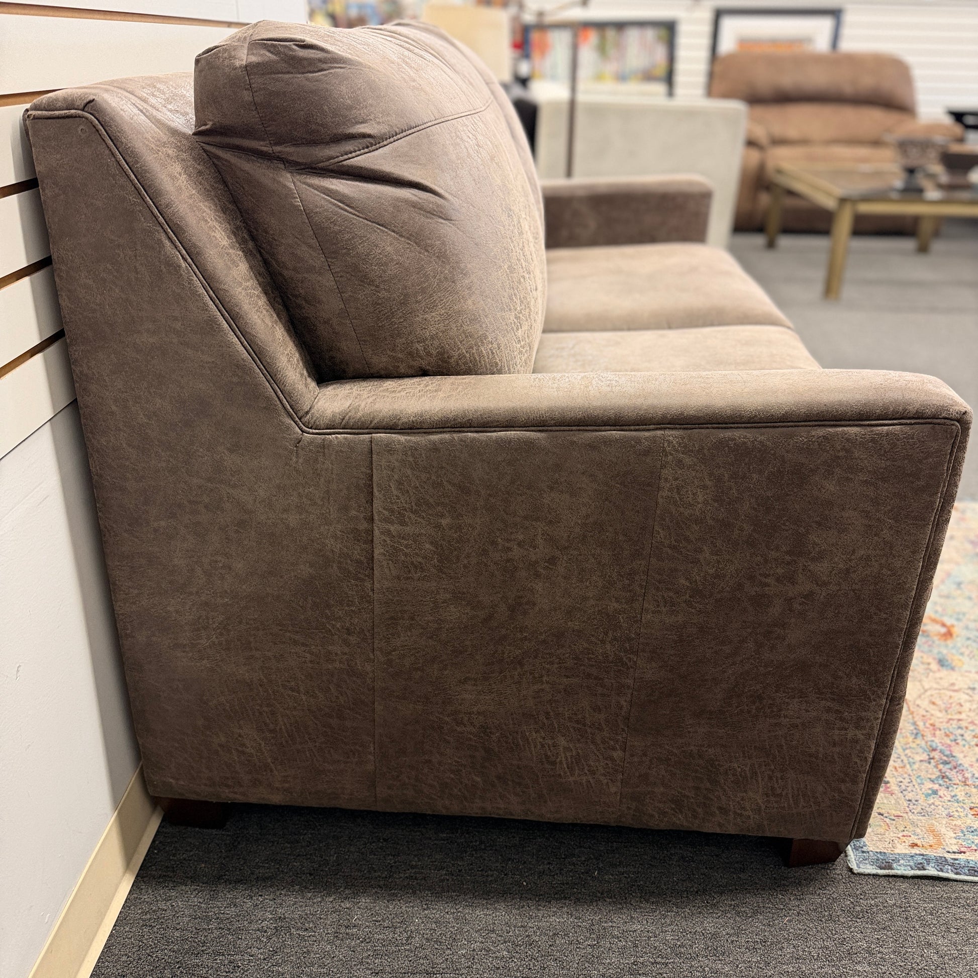 A plush two-seater sleeper sofa with pillow-top backrests and tapered track arms in textured distressed taupe-brown fabric.