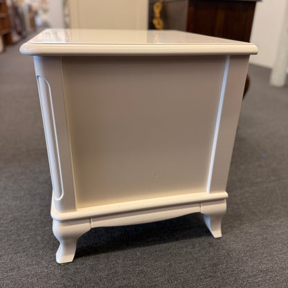 An off-white wooden nightstand featuring a single drawer with a turned knob, an open lower cubby, and curved cabriole legs.