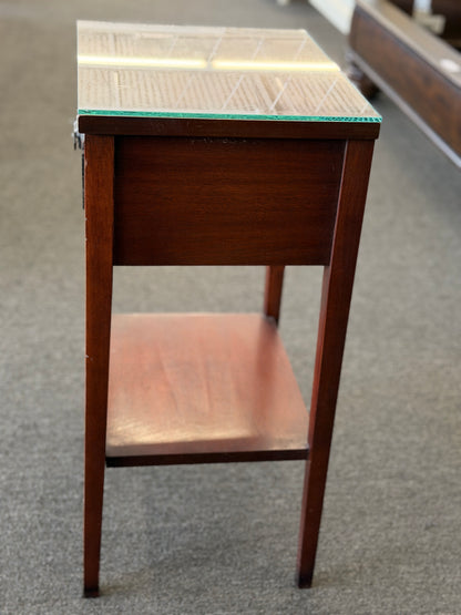 A Federal-style wood accent table featuring fluted corner accents, an arched apron, an oval rosette drop pull, an open lower shelf, and a glass top in good condition.