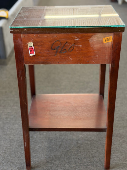 A Federal-style wood accent table featuring fluted corner accents, an arched apron, an oval rosette drop pull, an open lower shelf, and a glass top in good condition.