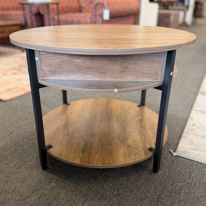 A round tiered wood-finish coffee table featuring a lift-top storage compartment in excellent condition.