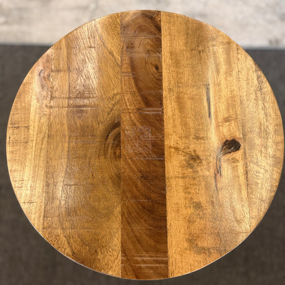 A minimalist round side table featuring a light wood tabletop and a black metal frame in excellent condition.