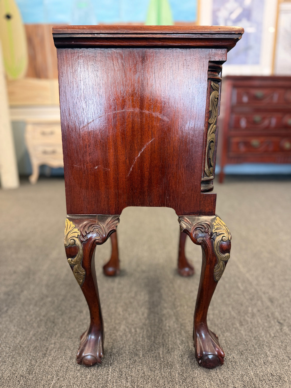 A Queen Anne-style two-drawer nightstand in rich mahogany featuring ornate brass hardware, cabriole legs, and ball-and-claw feet in good condition.