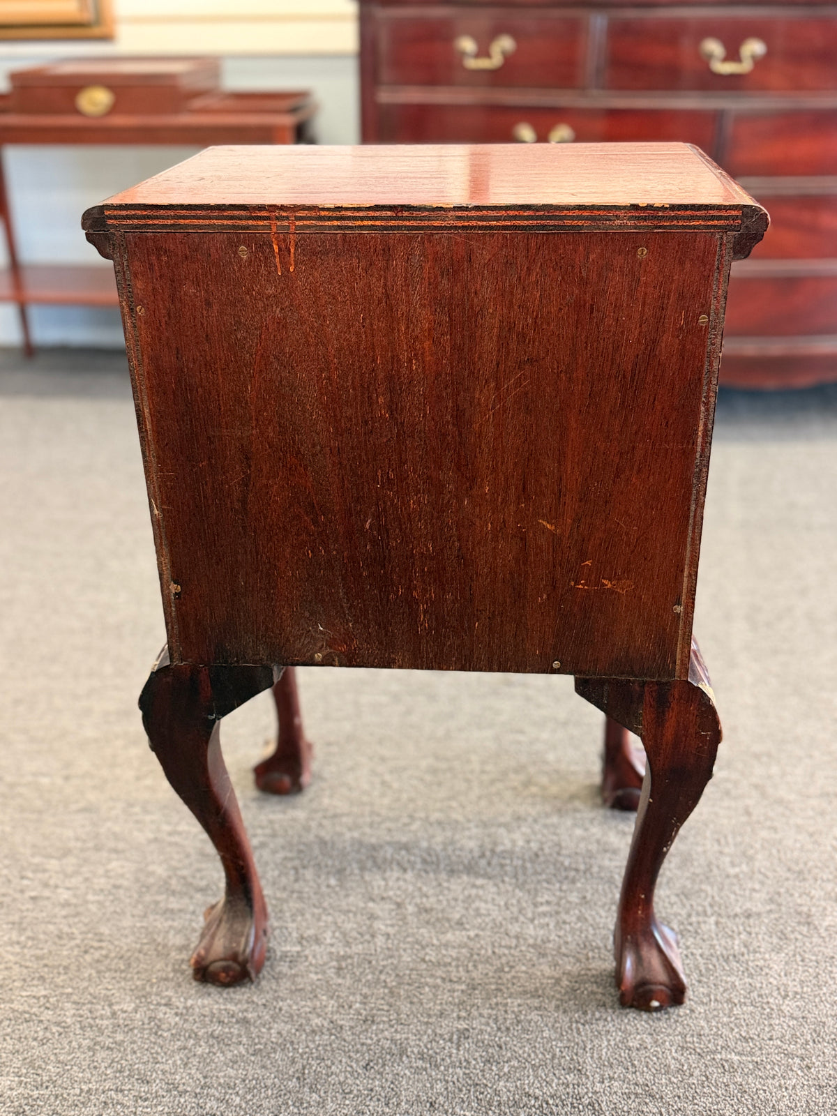 A Queen Anne-style two-drawer nightstand in rich mahogany featuring ornate brass hardware, cabriole legs, and ball-and-claw feet in good condition.