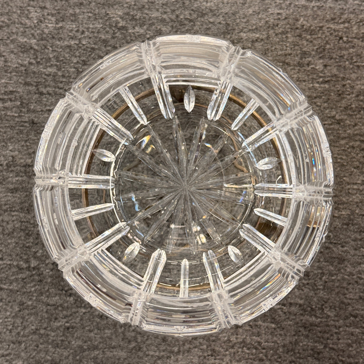 A geometric cut-crystal bowl set on an ornate antique brass-finished tripod stand in excellent condition.