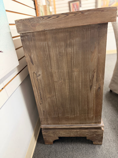A large rustic Mediterranean-style credenza sideboard crafted from weathered wood featuring four relief-carved cabinet doors and three center drawers with dark ring pulls in good condition.