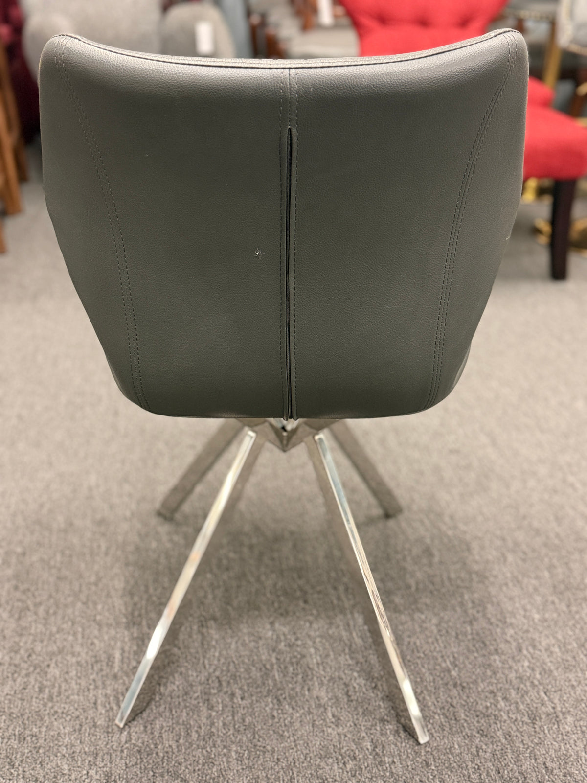 An accent office chair featuring sleek charcoal-gray faux leather upholstery with stitched seams, set on four angled chrome legs in good condition.