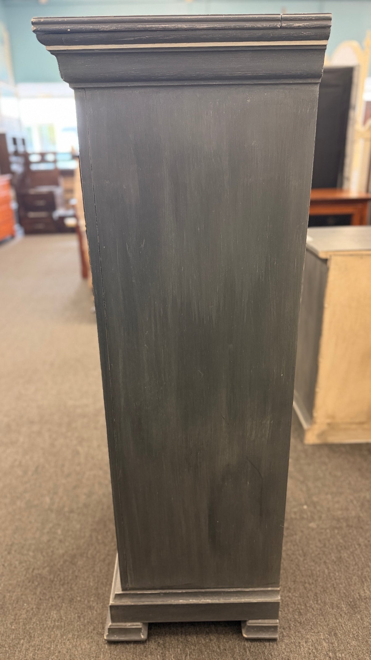 A tall slender Bassett jewelry armoire finished in distressed slate gray with white trim line detailing, six front drawers, and a flip-top lid with interior mirror in excellent condition.
