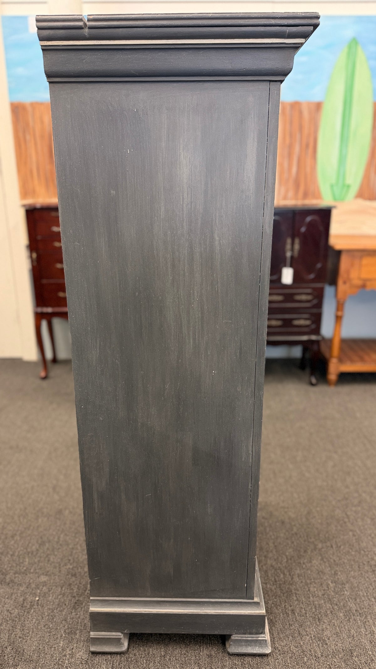 A tall slender Bassett jewelry armoire finished in distressed slate gray with white trim line detailing, six front drawers, and a flip-top lid with interior mirror in excellent condition.