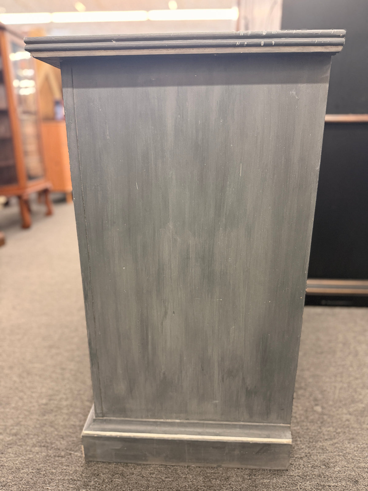 A six-drawer double dresser in a distressed charcoal black finish framed with light pinstripe bordering and ornate round brass-finish pull knobs in good condition.
