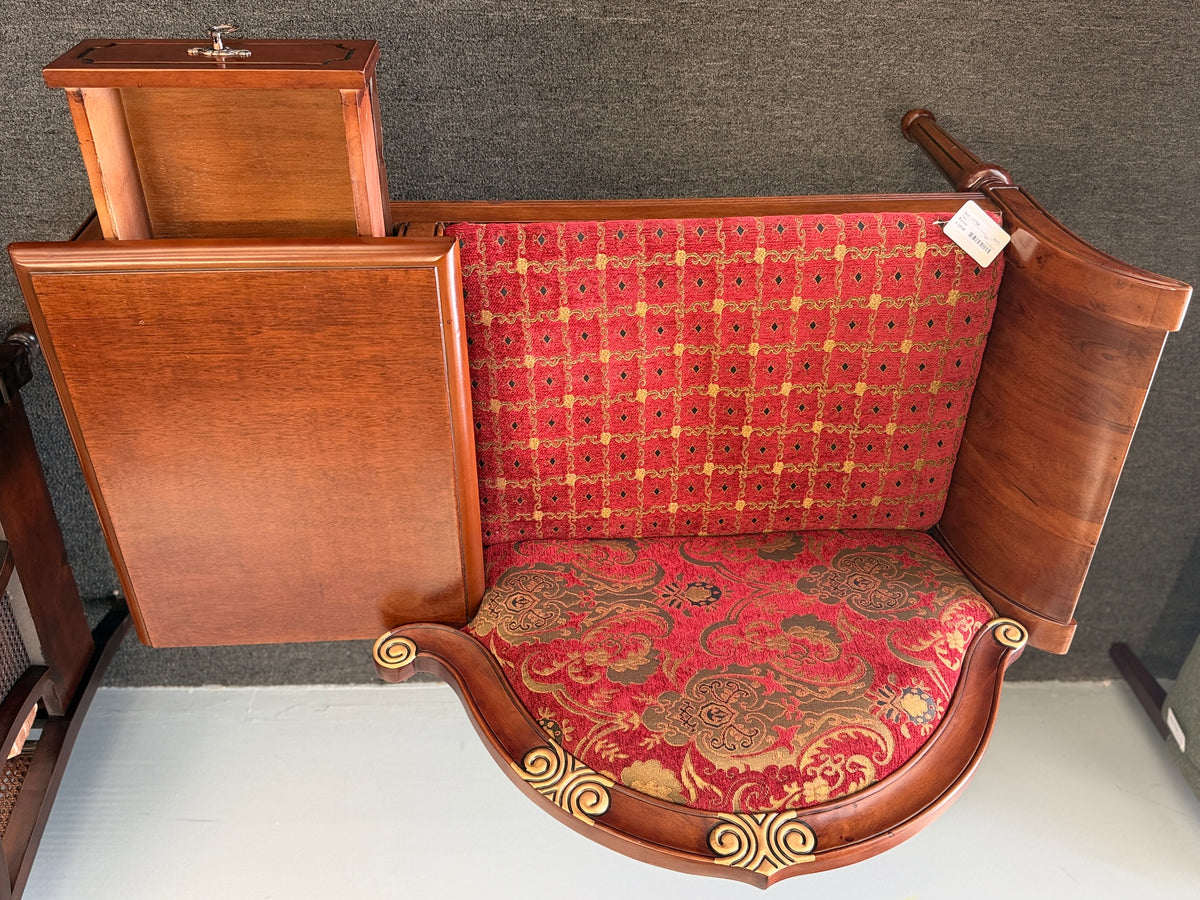 An antique-style wooden telephone chair featuring a single seat with red patterned upholstery, gold-accented scrollwork, an attached side tabletop, and a drawer in excellent condition.