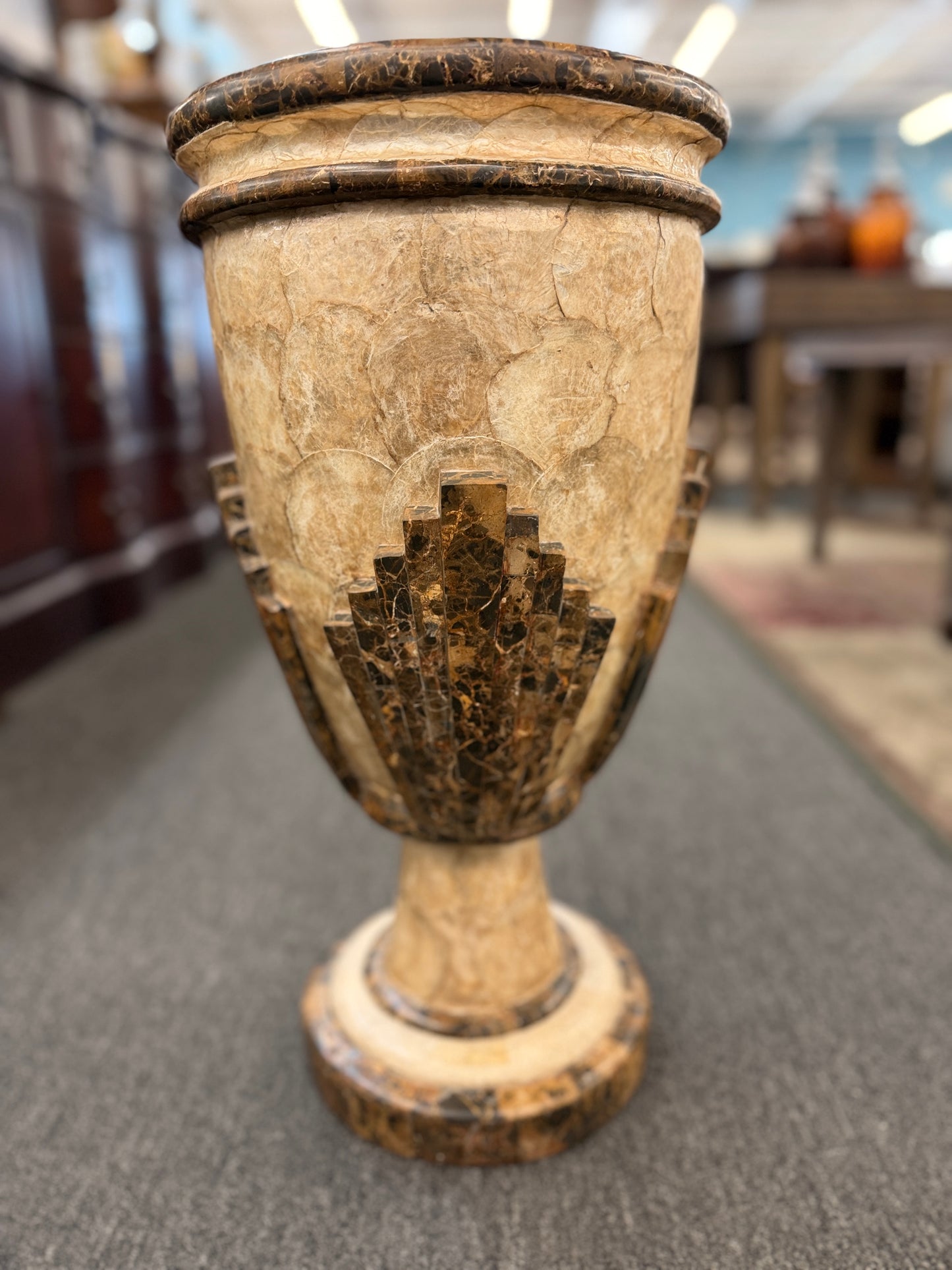 A tall Art Deco-inspired decorative vase featuring a textured light capiz-style overlapping circular pattern body with dark faux-marble geometric stepped accents and base.