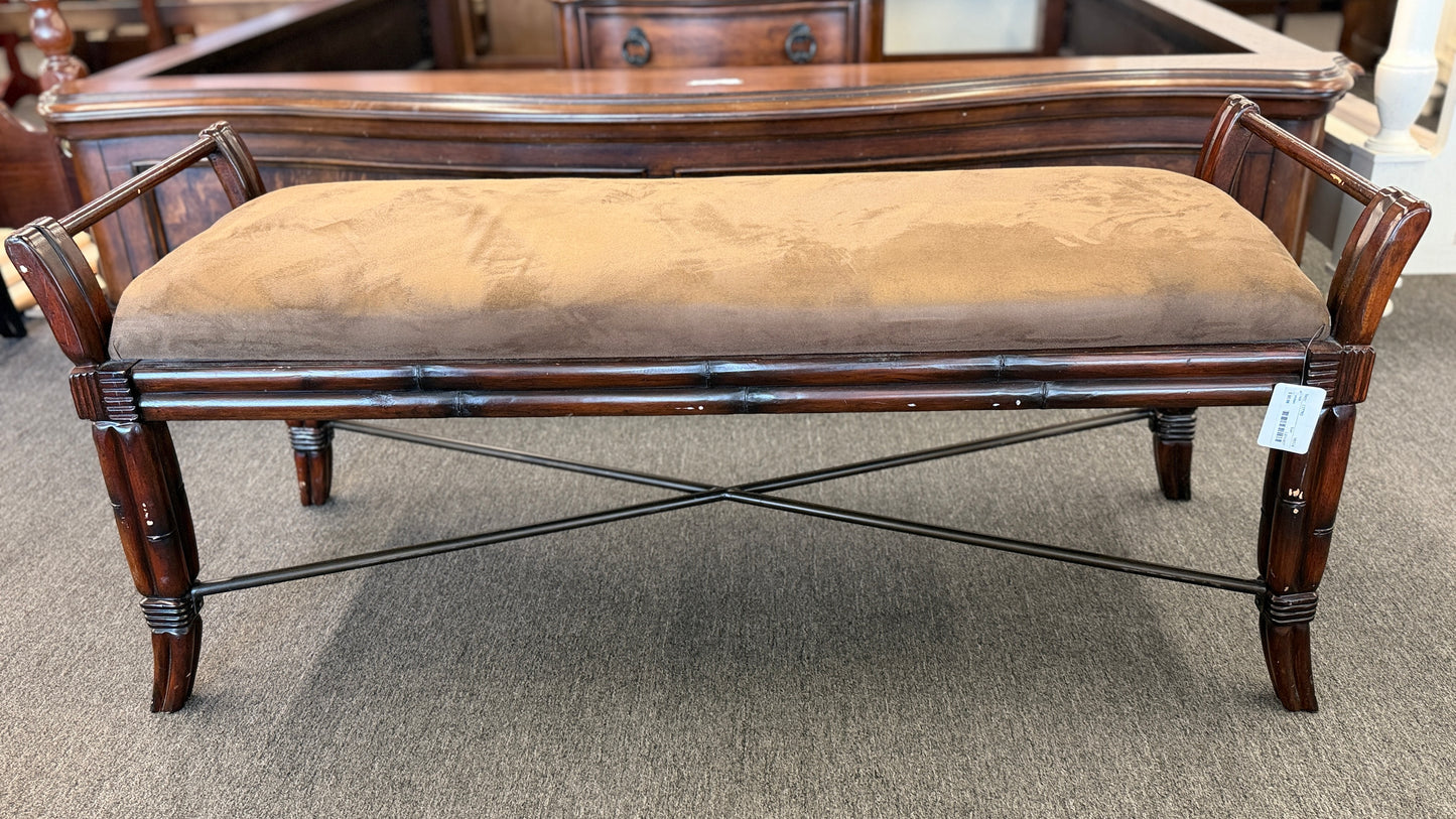 A wooden bench featuring bamboo-style framing, metal cross-stretchers, and a brown upholstered seat in good condition.