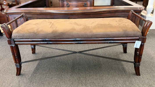 A wooden bench featuring bamboo-style framing, metal cross-stretchers, and a brown upholstered seat in good condition.