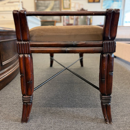 A wooden bench featuring bamboo-style framing, metal cross-stretchers, and a brown upholstered seat in good condition.