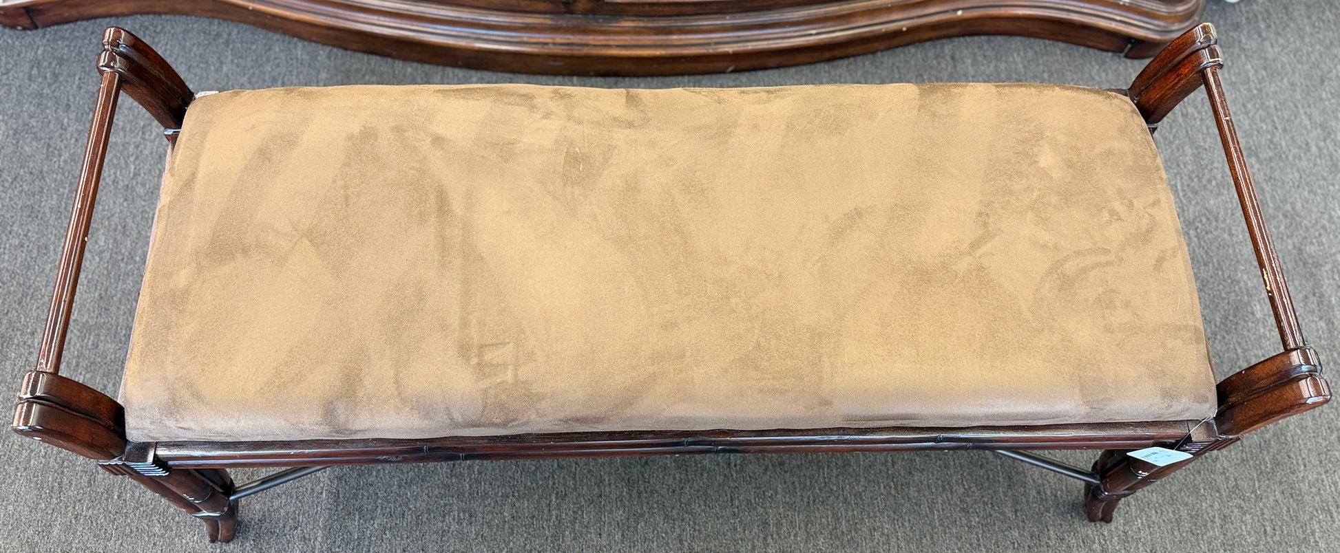 A wooden bench featuring bamboo-style framing, metal cross-stretchers, and a brown upholstered seat in good condition.