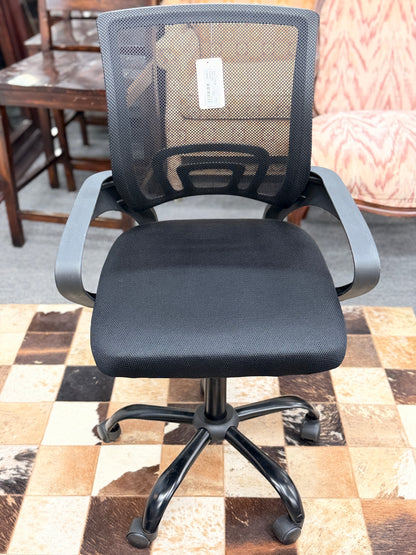 A standard black office chair with a breathable mesh backrest, padded fabric seat cushion, fixed armrests, and a five-point rolling star base.