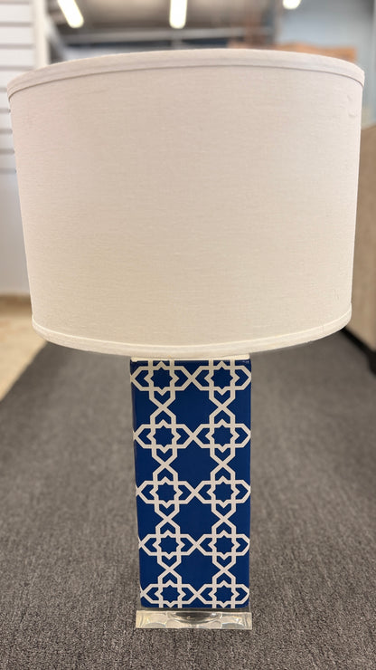 Blue and white ceramic table lamp featuring a geometric trellis pattern, rectangular column base, clear square plinth, and white fabric drum shade.