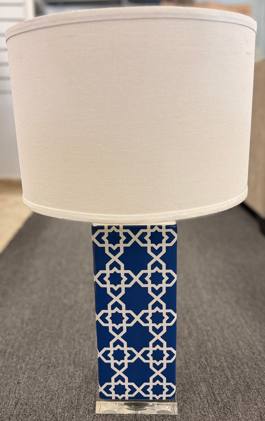 Blue and white ceramic table lamp featuring a geometric trellis pattern, rectangular column base, clear square plinth, and white fabric drum shade.