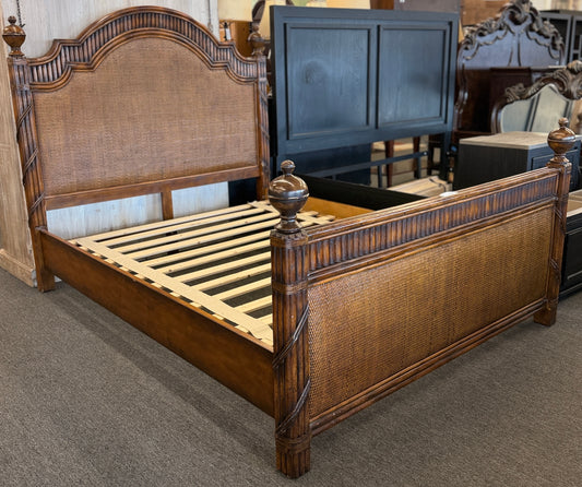 Carved wooden queen bed frame featuring arched woven rattan and cane panels on the headboard and footboard, accented with fluted posts and finials in excellent condition.