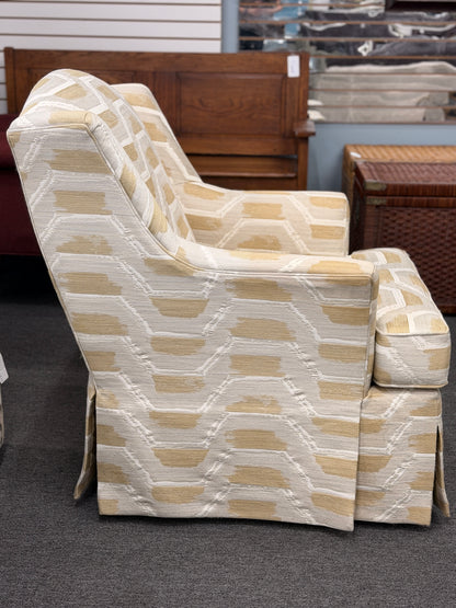 Fully upholstered wingback accent armchair with a tailored skirt featuring an off-white and tan or gold chevron-style geometric pattern in excellent condition.