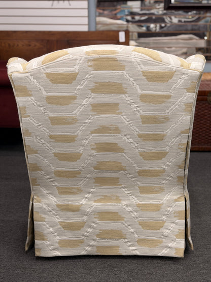 Fully upholstered wingback accent armchair with a tailored skirt featuring an off-white and tan or gold chevron-style geometric pattern in excellent condition.