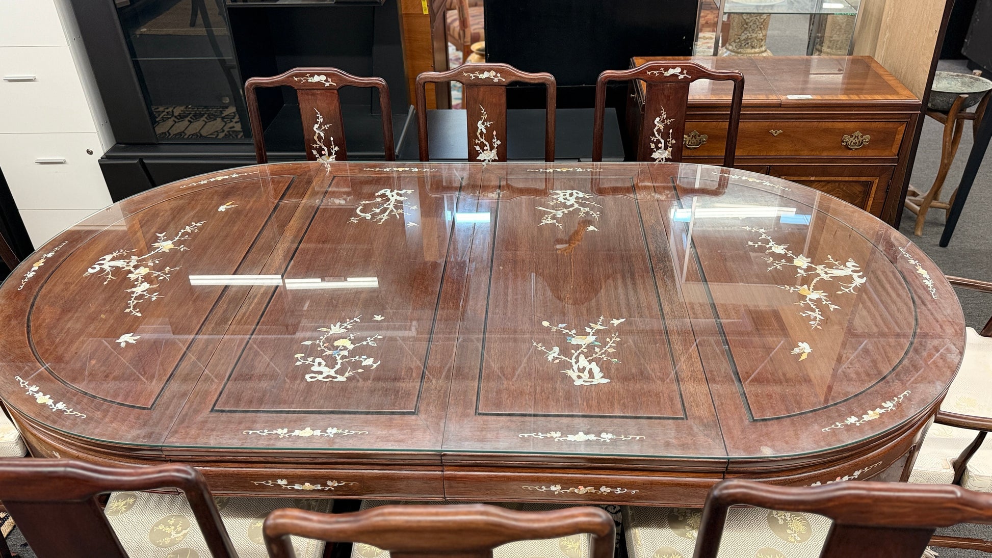 Chinoiserie inlaid wood 9pc oval dining set featuring a glass top table and mother of pearl detail at 2nd Debut Houston consignment showroom