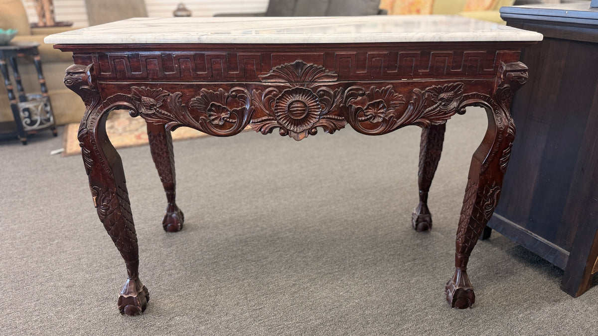 A Chippendale-style marble-top console table featuring an intricately carved mahogany apron, Greek key border, and cabriole legs with ball-and-claw feet in good condition.