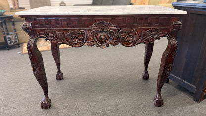 A Chippendale-style marble-top console table featuring an intricately carved mahogany apron, Greek key border, and cabriole legs with ball-and-claw feet in good condition.