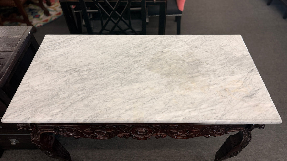 A Chippendale-style marble-top console table featuring an intricately carved mahogany apron, Greek key border, and cabriole legs with ball-and-claw feet in good condition.