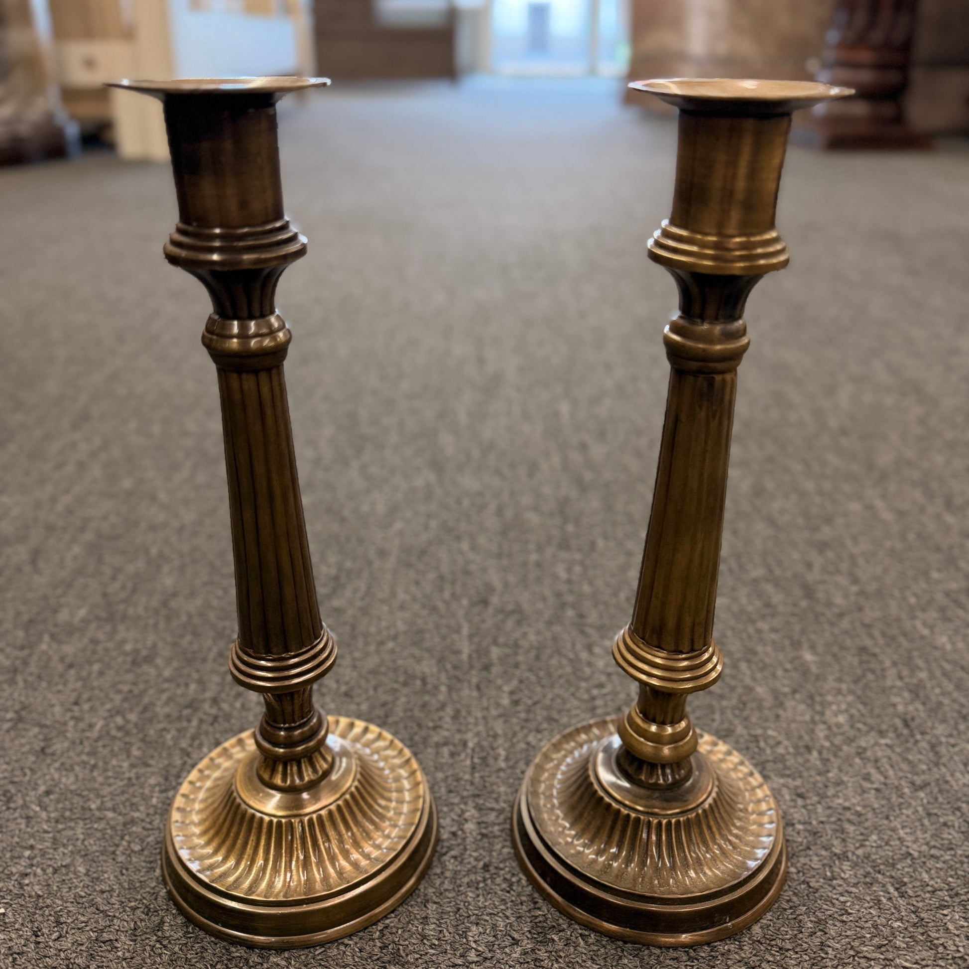 A pair of classic fluted brass candlesticks standing 11 inches tall with round bases in excellent condition.