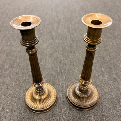 A pair of classic fluted brass candlesticks standing 11 inches tall with round bases in excellent condition.