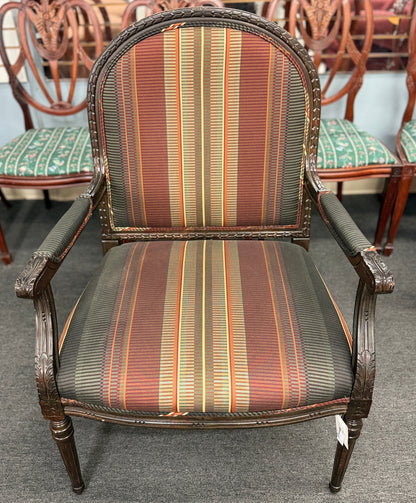 A classic French-style accent armchair with a dark wood frame, an oval medallion backrest, fluted straight legs, and traditional striped fabric upholstery.