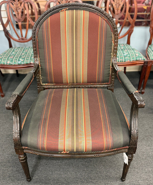 A classic French-style accent armchair with a dark wood frame, an oval medallion backrest, fluted straight legs, and traditional striped fabric upholstery.