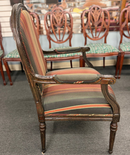 A classic French-style accent armchair with a dark wood frame, an oval medallion backrest, fluted straight legs, and traditional striped fabric upholstery.