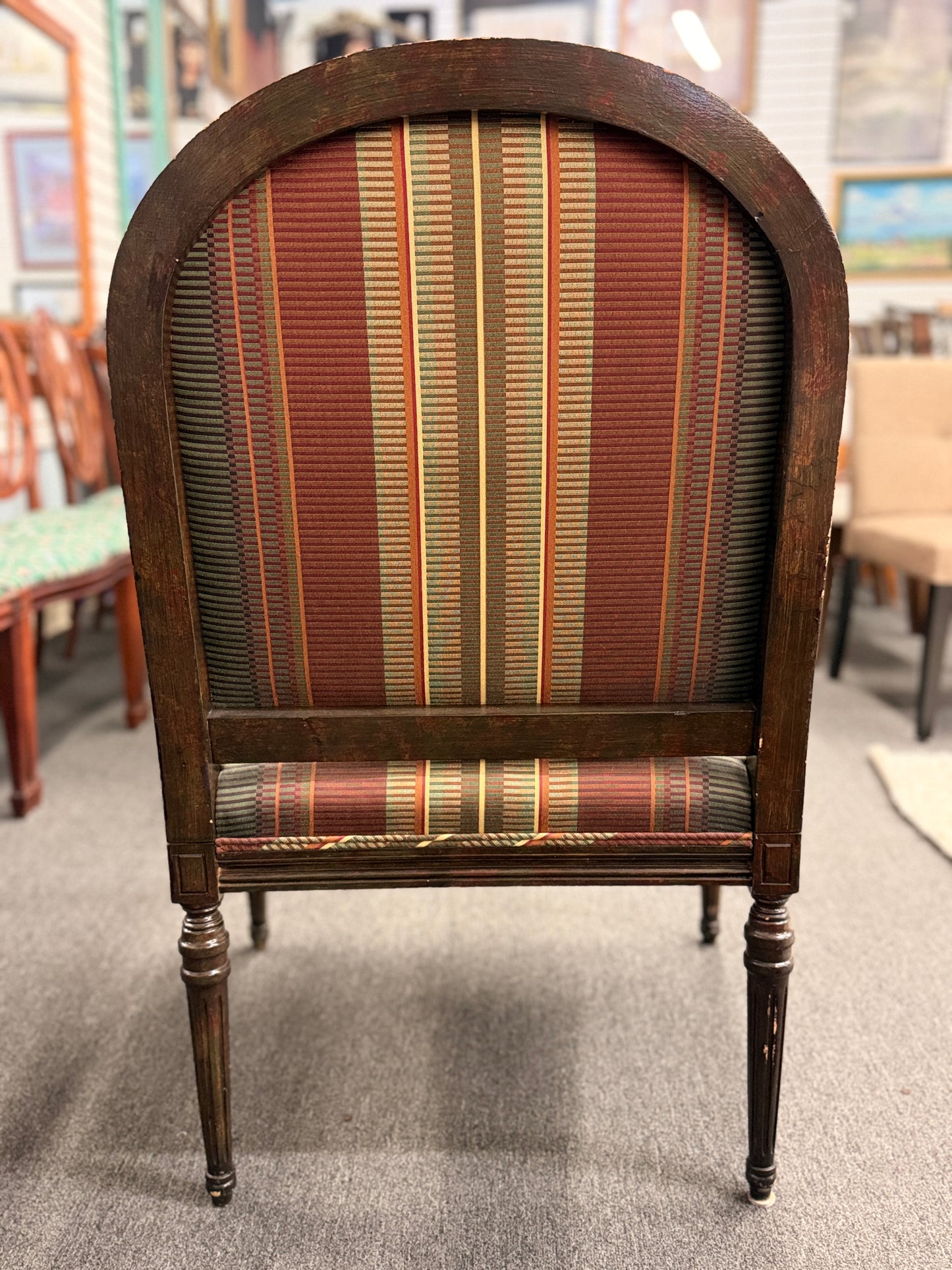 A classic French-style accent armchair with a dark wood frame, an oval medallion backrest, fluted straight legs, and traditional striped fabric upholstery.