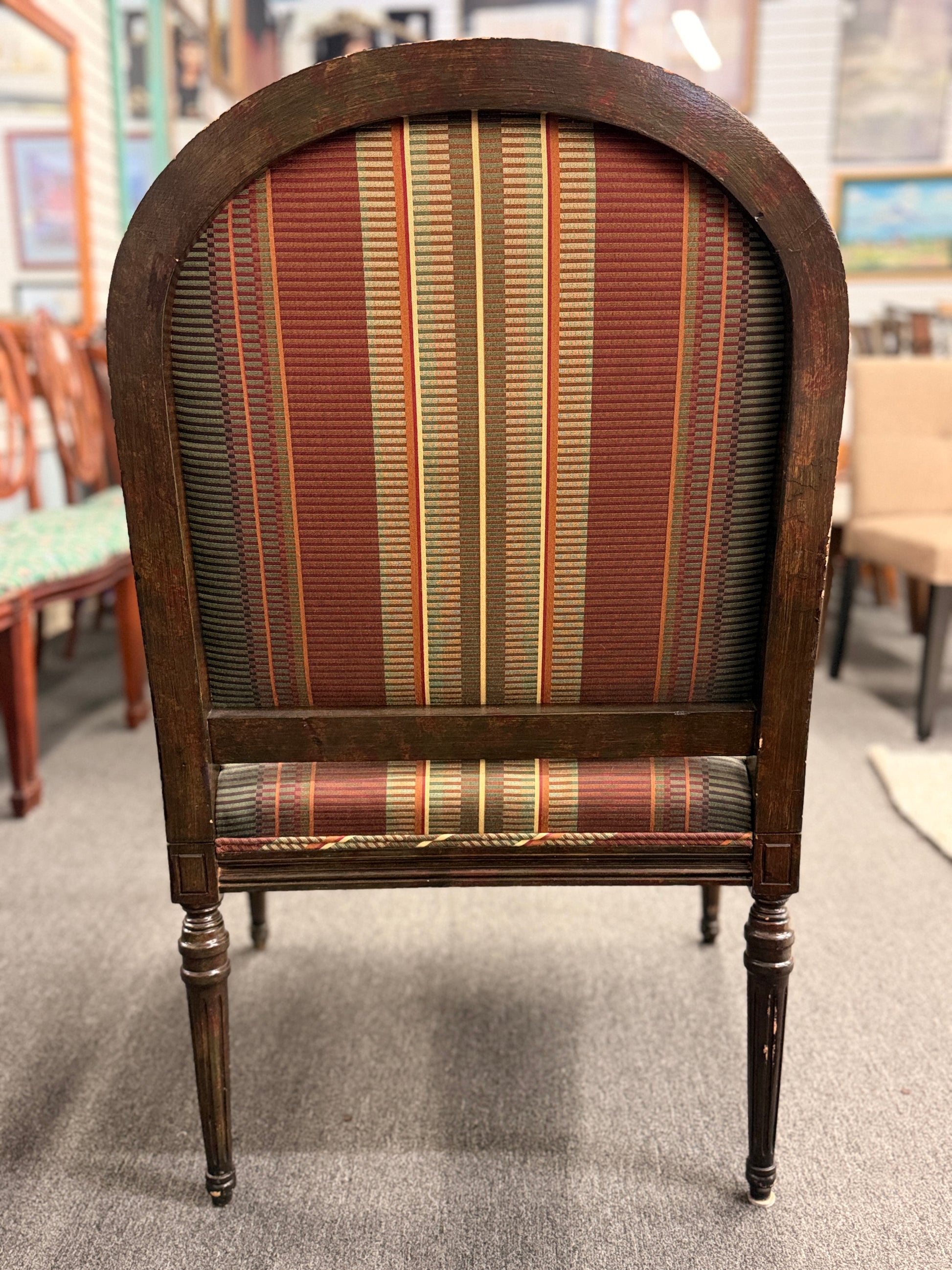 A classic French-style accent armchair with a dark wood frame, an oval medallion backrest, fluted straight legs, and traditional striped fabric upholstery.