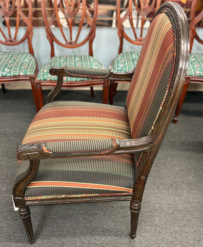 A classic French-style accent armchair with a dark wood frame, an oval medallion backrest, fluted straight legs, and traditional striped fabric upholstery.