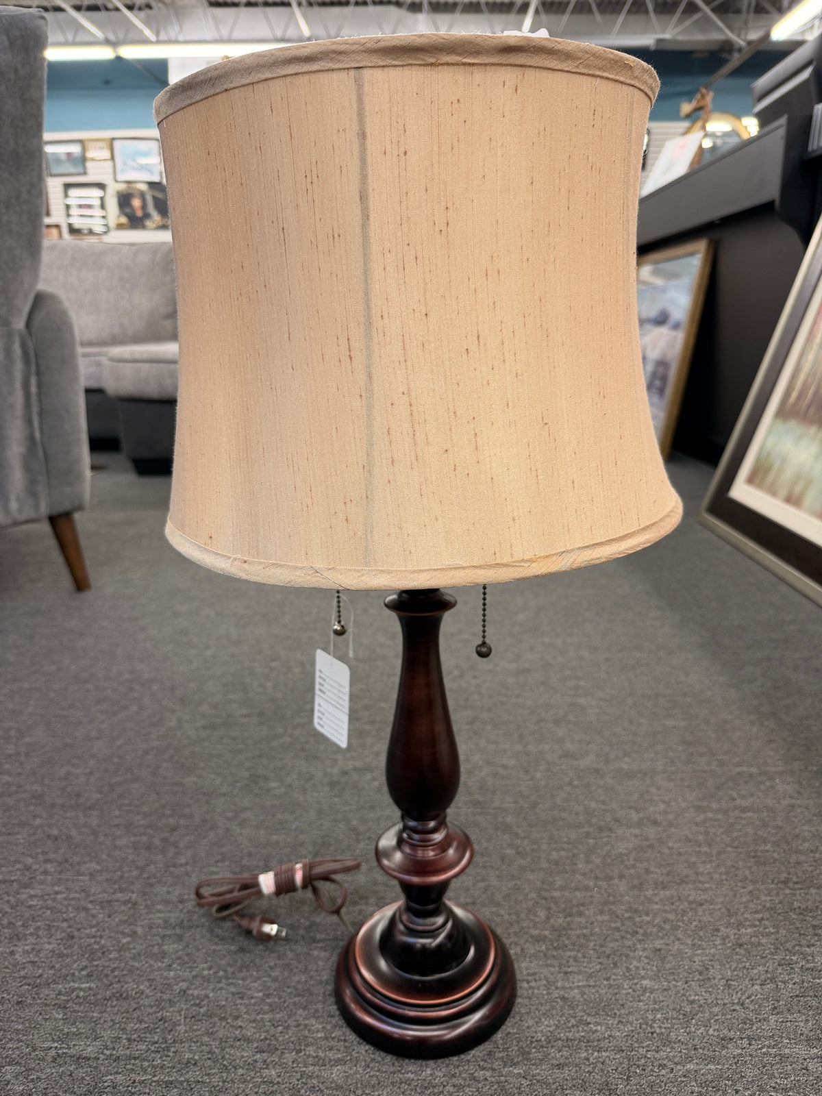 A classic accent table lamp featuring an oil-rubbed bronze turned-pedestal base, dual pull-chain switches, and a flared textured beige fabric shade in good condition.